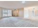Bright living area featuring plush carpeting, adjacent to an open dining space with tile flooring and modern lighting at 17443 N 99Th N Dr, Sun City, AZ 85373