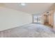 Spacious living room with neutral carpet, white walls and large window, offering a blank canvas for personalization at 17443 N 99Th N Dr, Sun City, AZ 85373
