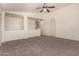 A spacious bedroom with neutral carpet, ceiling fan, and a vaulted ceiling at 18856 N Comet Trl, Maricopa, AZ 85138