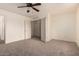 A spacious bedroom with neutral carpet, ceiling fan, and a walk in closet at 18856 N Comet Trl, Maricopa, AZ 85138
