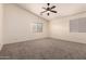 Bedroom featuring neutral carpet, ceiling fan, and a window at 18856 N Comet Trl, Maricopa, AZ 85138