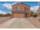 Two story home featuring a two car garage, shutters, landscaped yard, and concrete driveway at 18856 N Comet Trl, Maricopa, AZ 85138