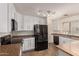 An open kitchen with white cabinets, stainless steel appliances, and a tile floor at 18856 N Comet Trl, Maricopa, AZ 85138
