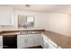 Bright kitchen featuring white cabinets, laminate counters, and stainless steel sink under a window at 18856 N Comet Trl, Maricopa, AZ 85138