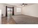 Bright living room with neutral carpet, ceiling fan, and sliding glass doors to the backyard at 18856 N Comet Trl, Maricopa, AZ 85138
