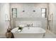 Luxurious bathroom featuring a standalone tub with decorative tile walls and stylish fixtures at 18886 N 101St Way, Scottsdale, AZ 85255