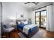 Cozy bedroom with wood floors, comfortable bed, and access to a private outdoor space at 18886 N 101St Way, Scottsdale, AZ 85255