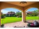 Inviting covered patio with archways offering scenic backyard views of lush greenery and neighborhood homes at 18886 N 101St Way, Scottsdale, AZ 85255