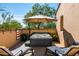 Relaxing deck featuring a hot tub with an umbrella, lounge chairs, and desert views at 18886 N 101St Way, Scottsdale, AZ 85255