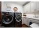Well-equipped laundry room with modern washer and dryer, storage cabinets, and a utility sink at 18886 N 101St Way, Scottsdale, AZ 85255