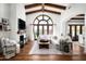 Bright living room boasts a large window, beamed ceilings, a white sofa and a fireplace at 18886 N 101St Way, Scottsdale, AZ 85255