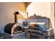 Gourmet outdoor kitchen with stone accents featuring a built-in pizza oven and a stainless steel grill at 18886 N 101St Way, Scottsdale, AZ 85255