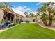 Large backyard with manicured artificial grass, patio area, and desert landscaping at 1954 E Vista Dr, Phoenix, AZ 85022