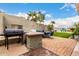 Expansive backyard featuring a built-in BBQ, patio seating, and artificial grass at 1954 E Vista Dr, Phoenix, AZ 85022
