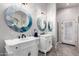 Elegant bathroom featuring dual vanities, decorative mirrors, and neutral color palette at 1954 E Vista Dr, Phoenix, AZ 85022