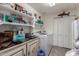 Functional laundry room with front loading washer/dryer, storage shelves, and custom cabinetry at 1954 E Vista Dr, Phoenix, AZ 85022