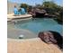 Backyard pool featuring rock waterfall, brick patio, and two blue Adirondack chairs at 1954 E Vista Dr, Phoenix, AZ 85022