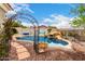 Backyard pool with desert landscaping, a rock waterfall, and an iron arbor at 1954 E Vista Dr, Phoenix, AZ 85022