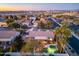 Aerial view of a home with a sparkling pool and lush backyard, set against a vibrant cityscape at 20497 E Appaloosa Dr, Queen Creek, AZ 85142
