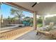 Relaxing backyard featuring a pool, covered patio, comfortable seating, and green turf at 20497 E Appaloosa Dr, Queen Creek, AZ 85142