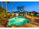 Beautiful backyard with pool, rock features, lush landscaping, and outdoor seating for entertaining under the stars at 20497 E Appaloosa Dr, Queen Creek, AZ 85142