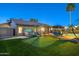 This backyard features a putting green, covered patio, hot tub and a pool, perfect for outdoor entertaining at 20497 E Appaloosa Dr, Queen Creek, AZ 85142