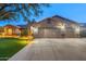 A home exterior featuring well-manicured landscaping, a large driveway, and stone accents at 20497 E Appaloosa Dr, Queen Creek, AZ 85142