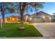 Well-manicured lawn and mature shade tree compliment this single-story home with a three-car garage at 20497 E Appaloosa Dr, Queen Creek, AZ 85142