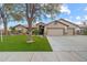 Charming single-story home with a three-car garage, well-manicured lawn, and mature shade tree at 20497 E Appaloosa Dr, Queen Creek, AZ 85142