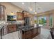 Spacious kitchen showcases a dark granite island, wood cabinetry, and views of outdoor foliage at 20497 E Appaloosa Dr, Queen Creek, AZ 85142