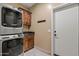 Functional laundry room with stackable washer and dryer, wooden cabinets, and stylish tile flooring at 20497 E Appaloosa Dr, Queen Creek, AZ 85142