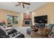 Comfortable living room with stone fireplace, large window, and a ceiling fan at 20497 E Appaloosa Dr, Queen Creek, AZ 85142