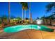 A breathtaking pool with a small rock waterfall and stunning outdoor lighting for evening enjoyment at 20497 E Appaloosa Dr, Queen Creek, AZ 85142