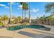 Relaxing pool area featuring a rock waterfall, palm trees, and ample space for outdoor enjoyment at 20497 E Appaloosa Dr, Queen Creek, AZ 85142