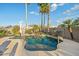 Beautiful private pool with rock waterfall feature, surrounded by mature palm trees and lush desert landscaping at 20497 E Appaloosa Dr, Queen Creek, AZ 85142