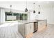 Bright kitchen island with granite countertops, stainless appliances, and sliding glass doors to backyard at 25339 N 19Th Ln, Phoenix, AZ 85085