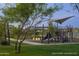 Playground featuring play structures, slides, and covered picnic area, set amidst green lawns and trees at 25339 N 19Th Ln, Phoenix, AZ 85085