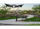 Community playground with modern play structures, picnic shelter, manicured lawns, and walking path at 25339 N 19Th Ln, Phoenix, AZ 85085