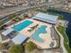 A high angle shows a community pool, splash pad, and seating next to a small lake at 25511 S 227Th St, Queen Creek, AZ 85142