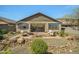 Relaxing backyard features desert landscaping, stone accents, and a welcoming brick patio with comfortable seating at 25511 S 227Th St, Queen Creek, AZ 85142