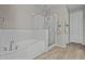 Bathroom with tiled floors, a soaking tub, and a separate glass-enclosed shower at 25511 S 227Th St, Queen Creek, AZ 85142