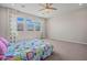 Bright bedroom with a ceiling fan, three windows and patterned curtains, creating a cozy atmosphere at 25511 S 227Th St, Queen Creek, AZ 85142