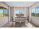 Bright dining area featuring a glass-top table with seating for six, surrounded by large windows and white curtains at 25511 S 227Th St, Queen Creek, AZ 85142