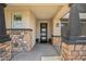 Covered front porch featuring stone pillars and a modern front door with decorative glass panels at 25511 S 227Th St, Queen Creek, AZ 85142