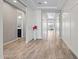 Bright hallway with wood-look tile flooring, white trim, and views into other rooms at 25511 S 227Th St, Queen Creek, AZ 85142