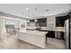 Modern kitchen with dark cabinets, a large island with a quartz countertop, and stainless steel appliances at 25511 S 227Th St, Queen Creek, AZ 85142