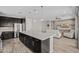 Open-concept kitchen with large island, stainless appliances, and dark cabinetry seamlessly connects to the living area at 25511 S 227Th St, Queen Creek, AZ 85142