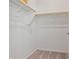 An empty walk-in closet with wooden rods for hanging clothes at 25511 S 227Th St, Queen Creek, AZ 85142