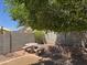 A shady backyard featuring a stone picnic table with benches under a mature tree at 25798 W Miami St, Buckeye, AZ 85326