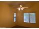 Cozy bedroom with vaulted ceiling, fan, and natural light from two windows at 25798 W Miami St, Buckeye, AZ 85326